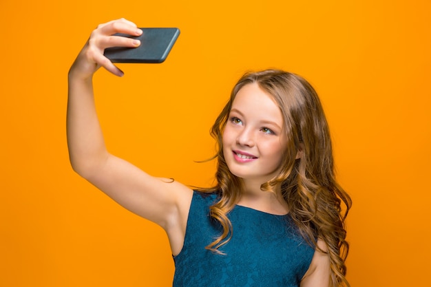 Foto gratuita la cara de juguetona niña adolescente feliz con teléfono