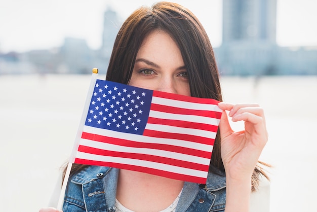 Cara de mujer joven que cubre con bandera americana