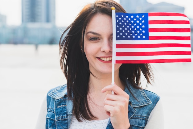 Cara de mujer joven que cubre con bandera americana