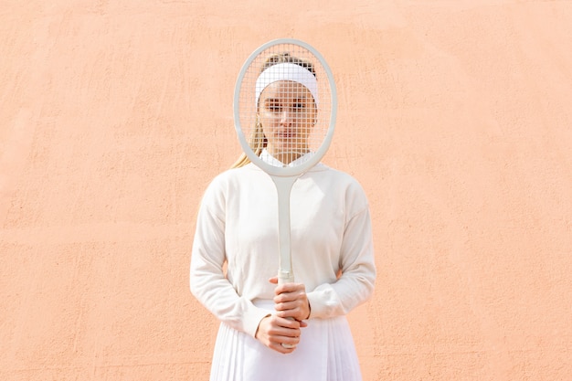 Cara de mujer joven con raqueta de tenis