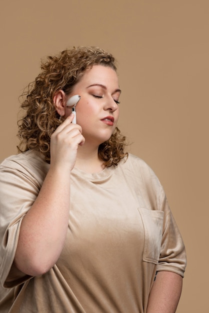 Foto gratuita cara de mujer de tiro medio masajeando con gua sha