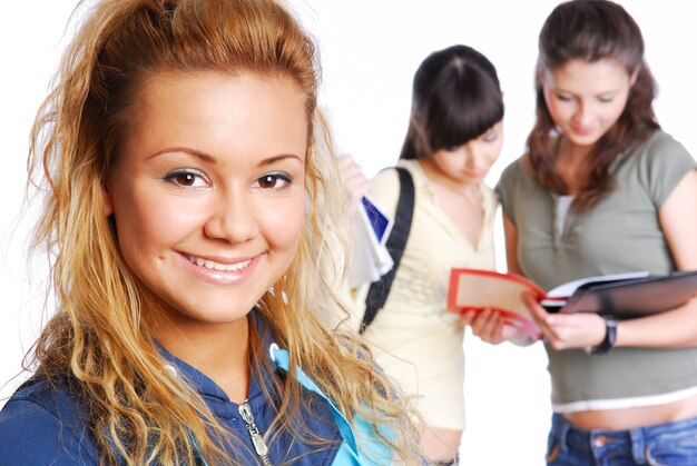 Cara de primer plano de linda estudiante - se centran en primer plano. Ðžn compañeros de clase de pie de fondo.