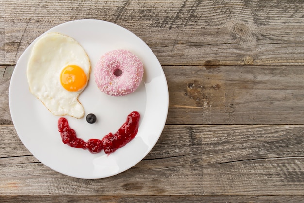 Cara sonriente de huevo frito y rosquilla