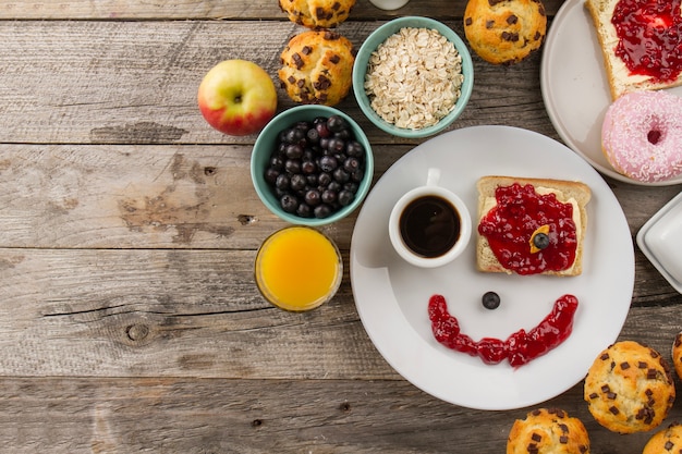 Foto gratuita cara sonriente de la taza de café y de la tostada