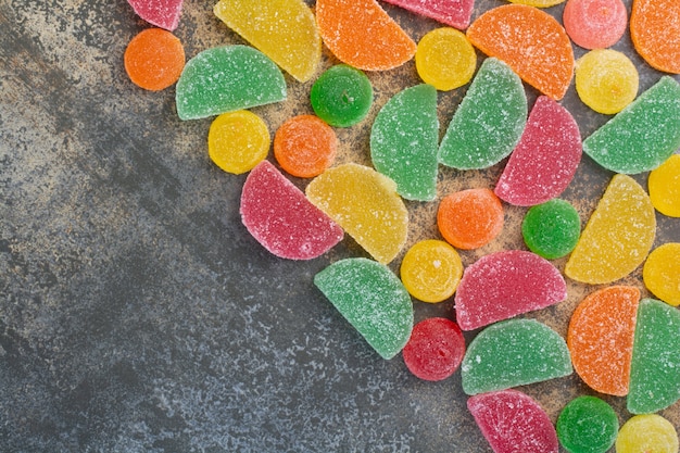 Caramelo dulce de gelatina de colores sobre fondo de mármol