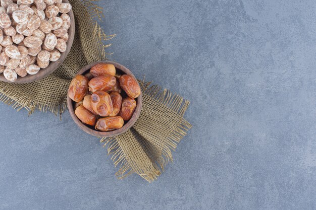 Foto gratuita caramelos de canela y frutos de dátil, sobre el fondo de mármol.