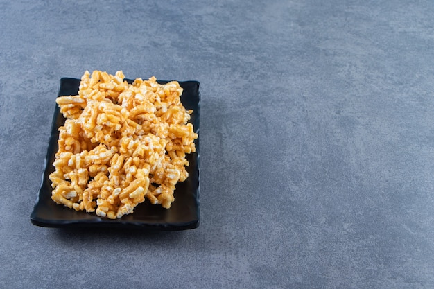 Caramelos de caramelo en un plato, sobre el fondo de mármol.