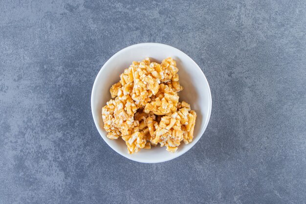 Caramelos de caramelo en un recipiente sobre la superficie de mármol