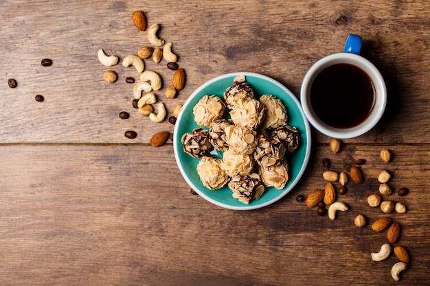 Caramelos de chocolate café y nueces sobre madera