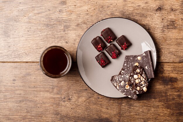 Caramelos de chocolate y café sobre madera.