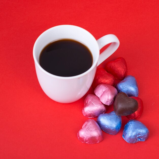 Caramelos de chocolate en forma de corazón con taza de café