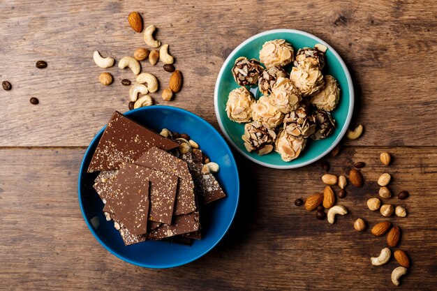 Caramelos de chocolate y nueces sobre madera