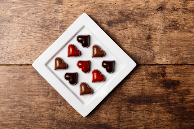 Foto gratuita caramelos de chocolate en plato blanco sobre madera