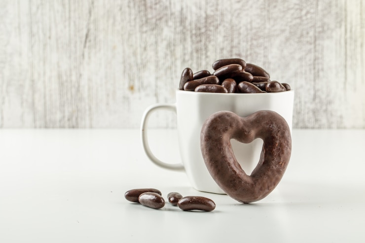 Foto gratuito caramelos de chocolate en una taza