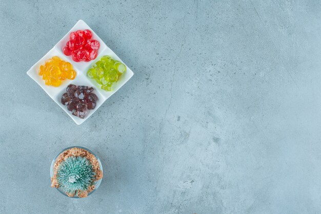 Caramelos de gelatina de colores con un árbol de Navidad en mármol.