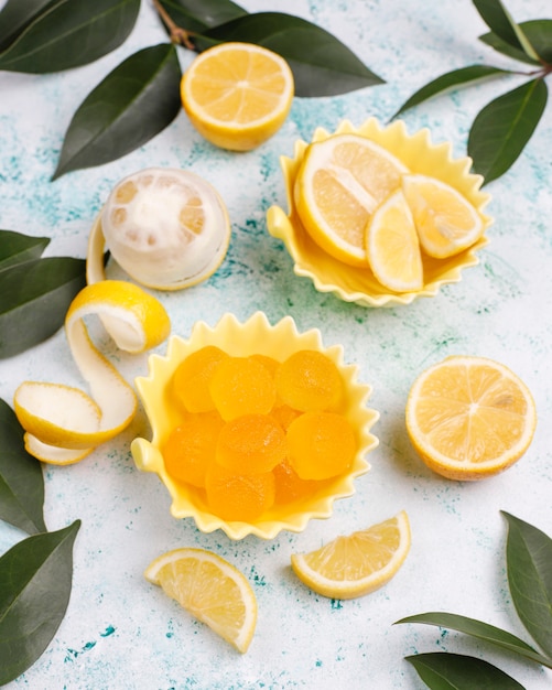 Caramelos de gelatina de limón con limones frescos, vista superior