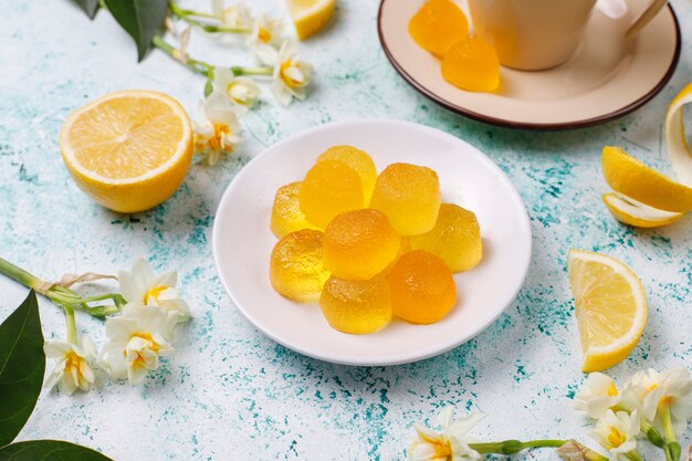 Caramelos de gelatina de limón con limones frescos, vista superior