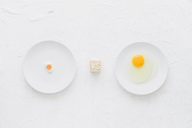 Caramelos de huevo versus yema de huevo en un plato blanco sobre fondo texturizado