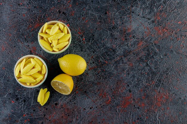 Caramelos de mascar en forma de plátano con limón fresco en un oscuro