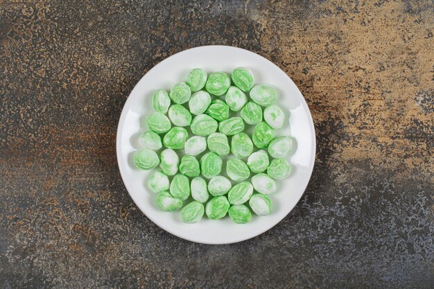 Caramelos de mentol verde en plato blanco.