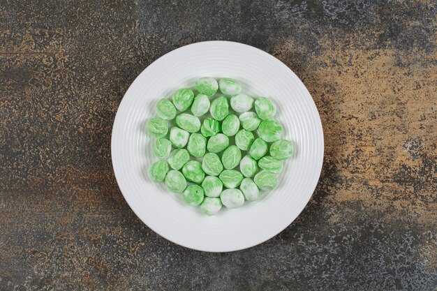 Caramelos de mentol verde en plato blanco.