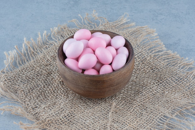 Foto gratuita caramelos rosas en la taza sobre el salvamanteles, sobre la mesa de mármol.