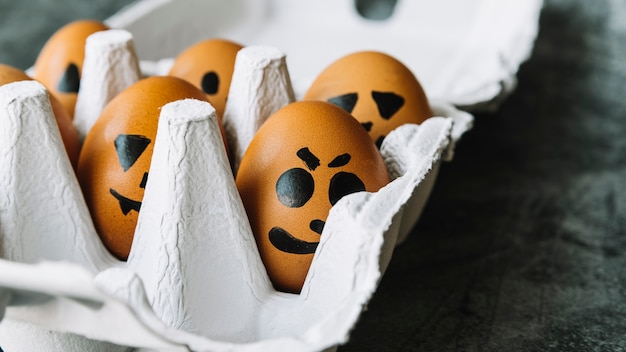 Caras de miedo en la imagen en los huevos que mienten en caja
