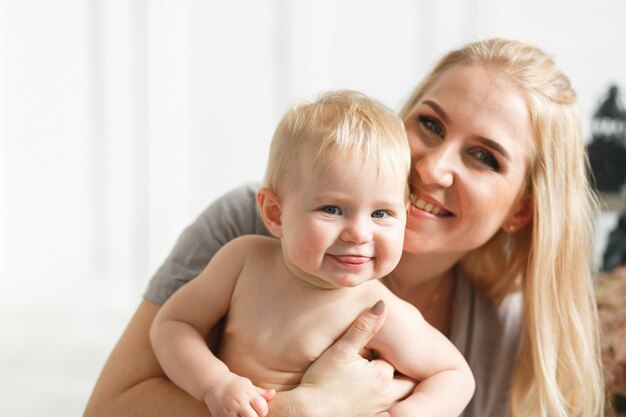 Caras de risa de la familia feliz, madre que celebra al bebé adorable del bebé