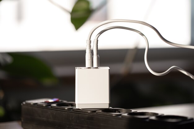 Carga USB blanca para gadgets sobre un fondo borroso de la habitación closeup
