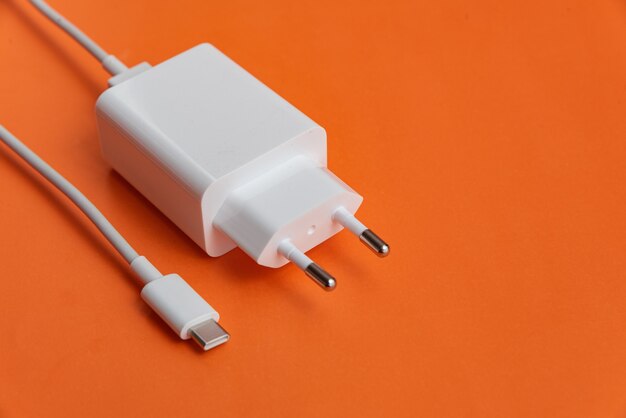 Cargador y cable USB tipo C sobre fondo naranja
