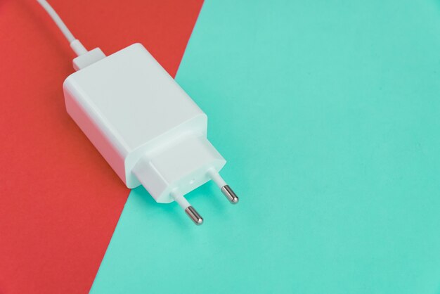 Cargador y cable USB tipo C sobre fondo rosa y azul