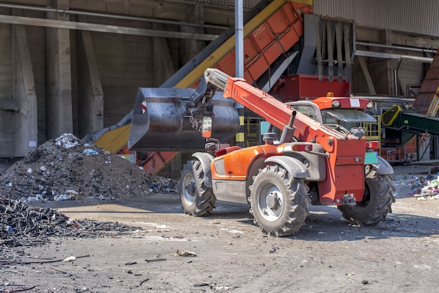 Cargador que transporta tierra y materiales de desecho en una planta de tratamiento de desechos