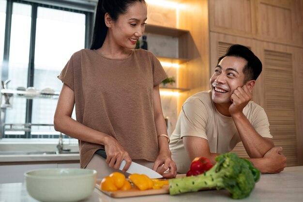 Cariñosa pareja cocinando juntos verduras en la cocina