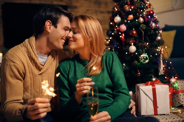 Cariñosa pareja disfrutando del amor en la víspera de Año Nuevo en casa