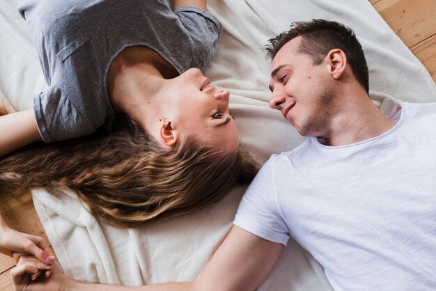 Cariñosa pareja feliz acostado en el piso juntos