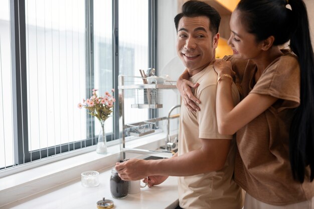 Cariñosa pareja haciendo café juntos en la cocina