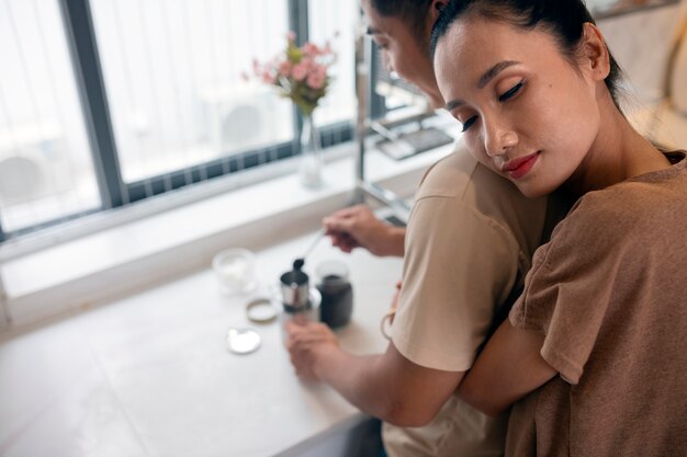 Cariñosa pareja haciendo café juntos en la cocina