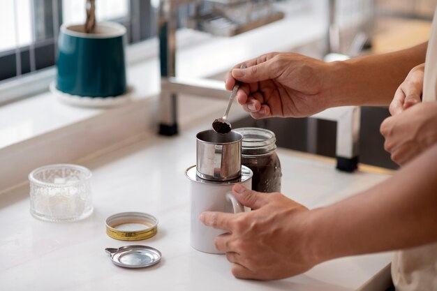 Cariñosa pareja haciendo café juntos en la cocina