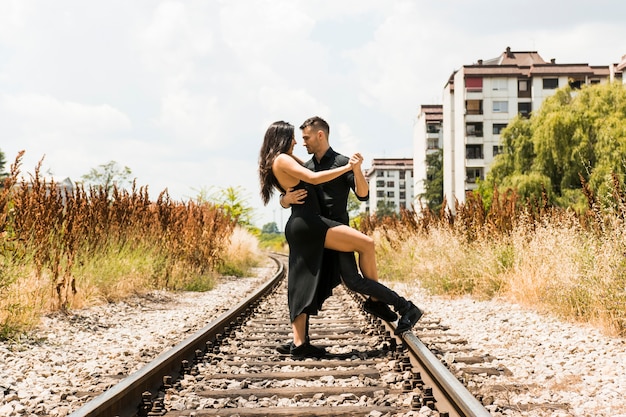 Foto gratuita cariñosa pareja joven bailando en el ferrocarril