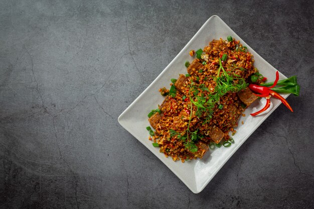 Carne de cerdo frita con chile seco y sal sobre fondo oscuro