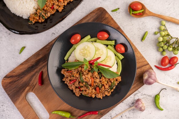 Carne de cerdo picada picante y arroz en un plato negro.