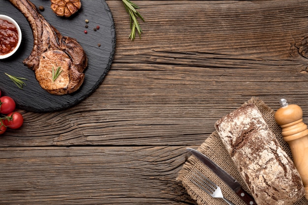 Carne cocida con salsa sobre tabla de madera con espacio de copia