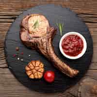Foto gratuita carne cocida con salsa sobre tabla de madera