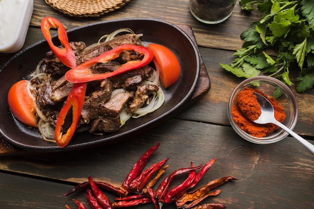 Foto gratuita carne cocida con tomates y pimientos en sartén