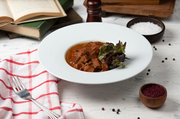 Carne de cordero de res salteada, guisada en salsa de browh y tomate, servida con verduras y sumakh.