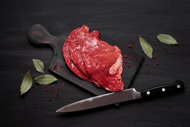 Foto gratuita carne cruda fresca sobre tabla de madera con cuchillo