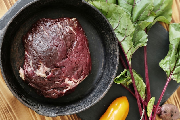 Carne cruda con ingredientes para cocinar