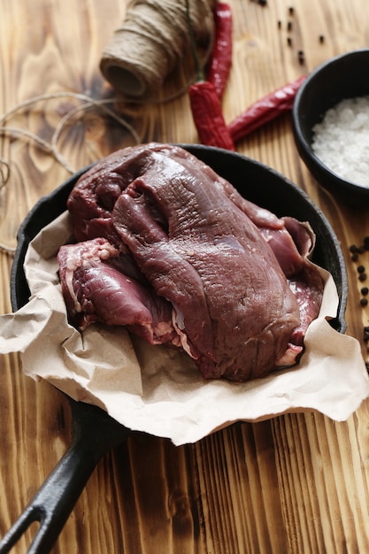 Carne cruda con ingredientes para cocinar