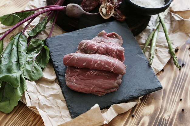 Carne cruda con ingredientes para cocinar