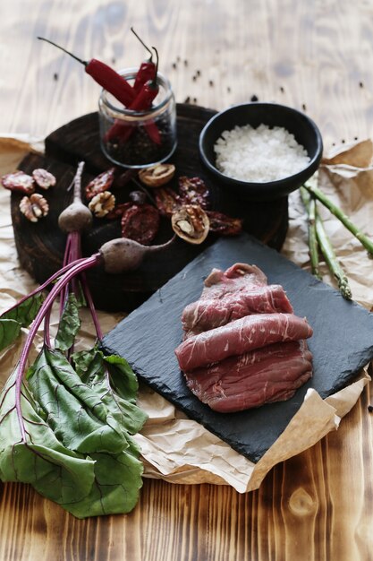 Carne cruda con ingredientes para cocinar